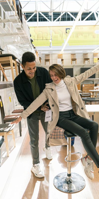 A cheerful couple enjoying their time shopping for furniture indoors.