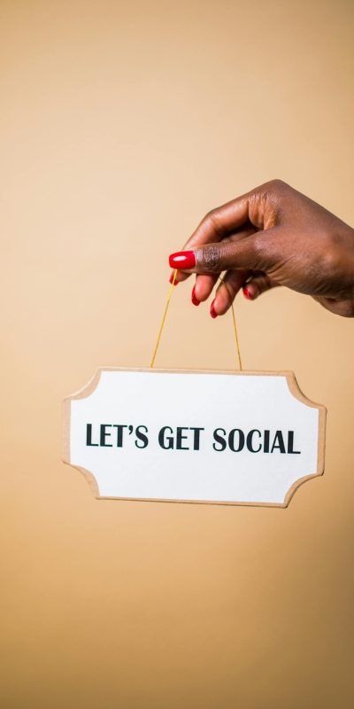 Photo by RDNE Stock project A hand holding a "Let's Get Social" sign, ideal for marketing and social media themes.