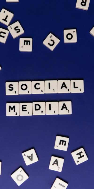Scrabble tiles spelling 'Social Media' on a blue background, ideal for digital marketing themes.